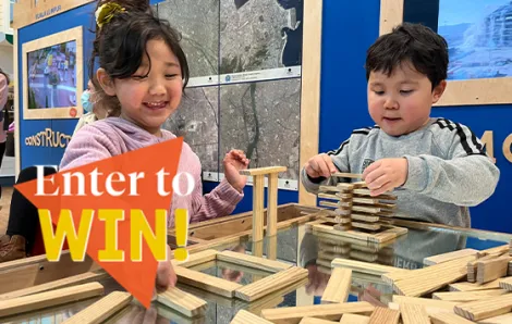 "Enter to Win" text over two kids building with wooden blocks at museum