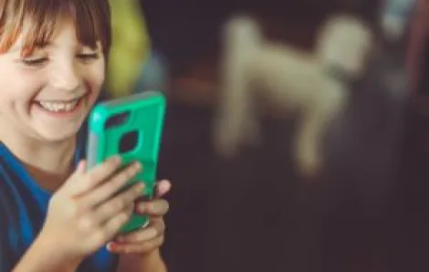 Cute laughing little girl using an alternative smartphone