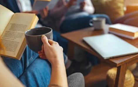 how to start a book club includes coffee and an open book around a table