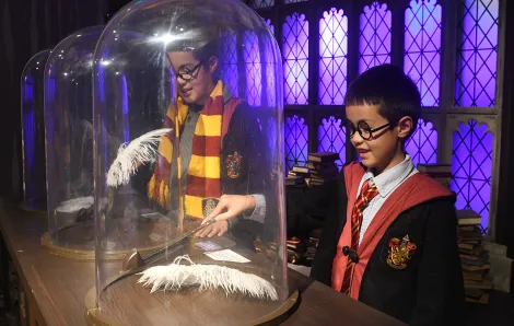 At Harry Potter: Magic at Play boys practice their wingardium leviosa spell in the Charms class at Hogwarts