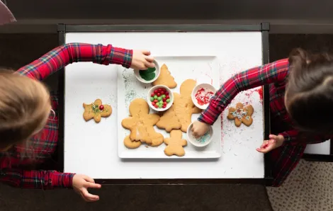 Two girls decorating gingerbread cookies