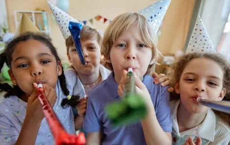 Kids at a birthday party with hats and party blowers