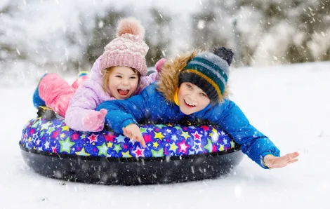 Kids on a sled with the best snow gear and toys