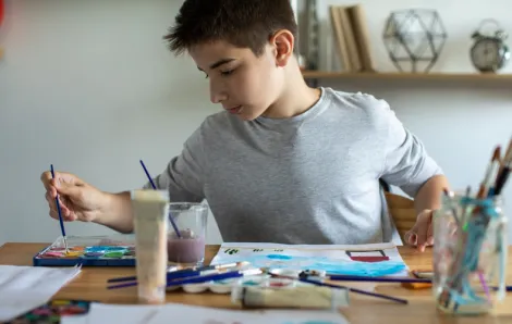 Teen boy painting at home is a volunteer opportunity for Seattle kids who love crafting
