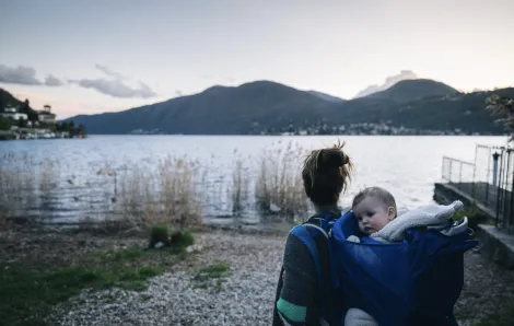 Mom carrying a baby in a backpack by a lake is a wonderful thing to do with a baby in Seattle