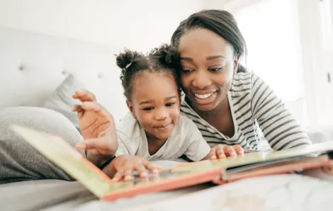 Mom and daughter reading a book about Black history