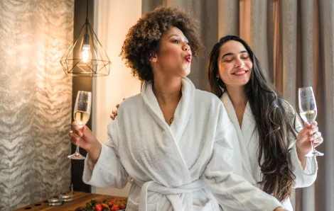 Two females relaxing with champagne wearing robes (credit iStock)