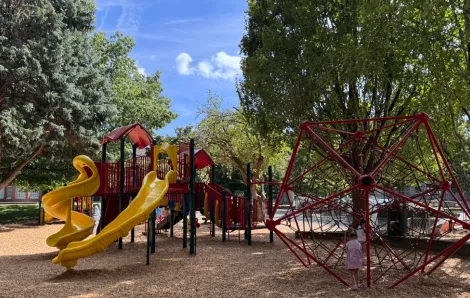kids playing in the shade on the playground by Veterans’ Memorial Field