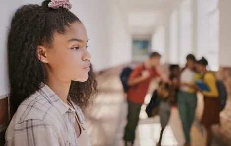 disappointed girl standing in a school hallway