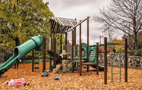 a young girl climbs on a playground in Seattle on a rainy day