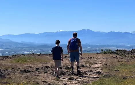 father and son hiking Upper Table Rock on a family trip to Southern Oregon