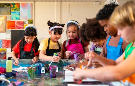 kids sitting around a table engaged in an art project