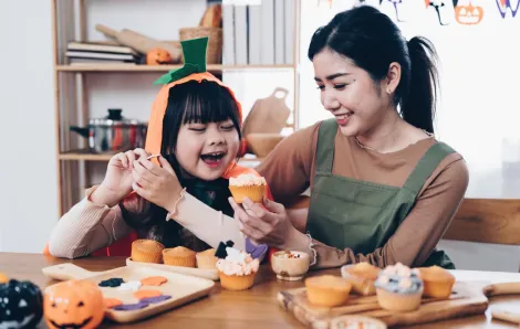 mom and daughter making Halloween treats together