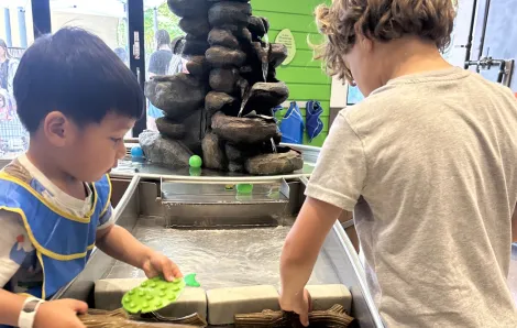 two kids working together at a water exhibit at KidsQuest Children's Museum
