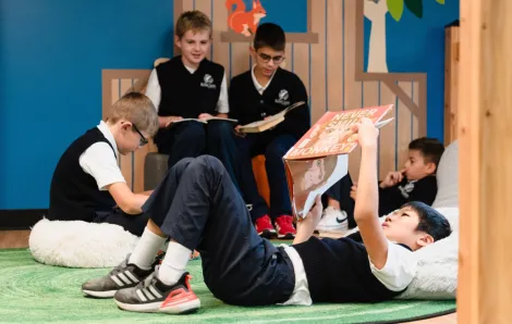 child reading on his back in a library