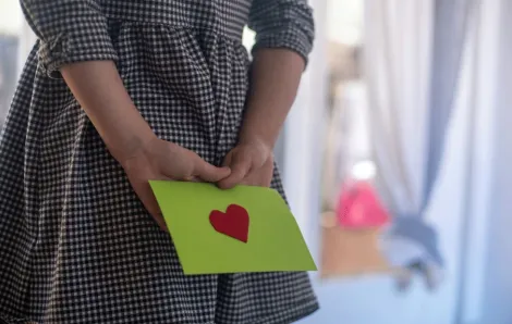 a green envelope with a heart contains a washington college savings account certificate