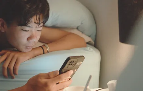 teen on bed looking at his phone