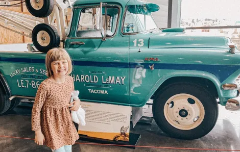 preteen in front of a truck at LeMay – America's Car Museum in Tacoma, a fun place to take kids