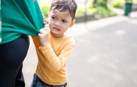 young boy tugging on his mother's shirt