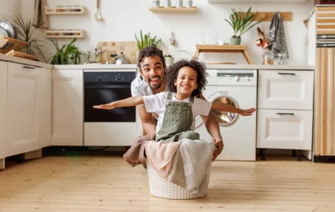 dad and child doing laundry together having fun