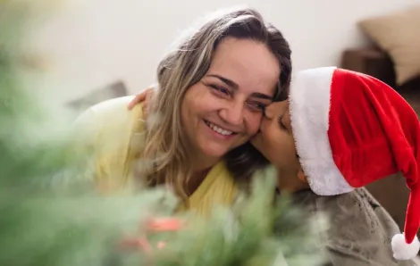 A boy hugs his mom on Christmas morning 