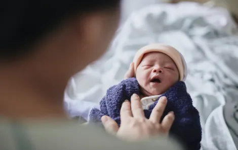 tiny new baby with a hat and blanket