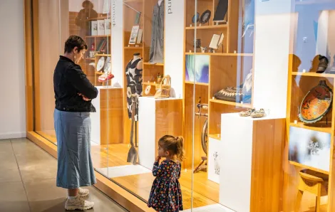 girl and mother looking at exhibit through glass at National nordic museum during a free museum day
