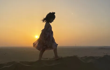 young girl walking on sand dunes