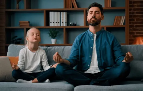 young father teaching little daughter meditation