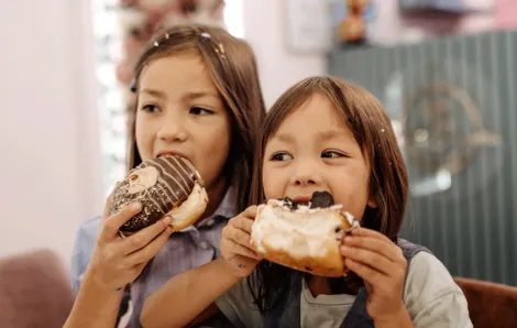 kids eating doughnuts on a walking food tour in Seattle