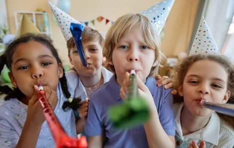 children holding party blowers and having fun
