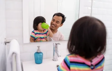 Little girl gargling after brushing her teeth