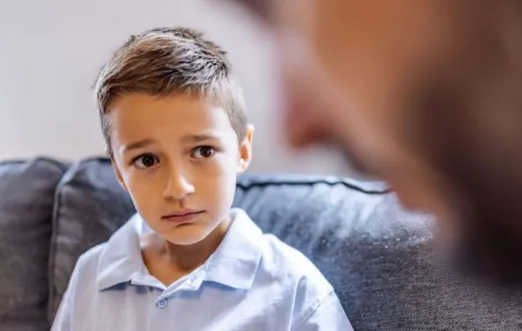worried little boy talking to adult