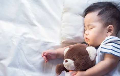 Newborn baby sleeping with teddy bear