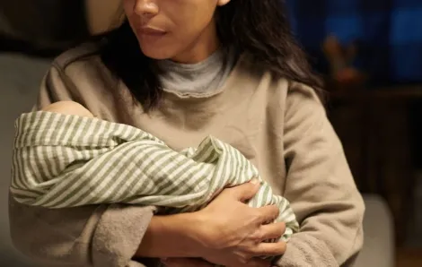 Caring mother holding newborn baby in her arms