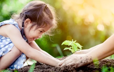 Girl helping plant during Earth Day event