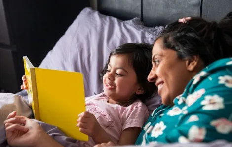 mother with kid reading in bed