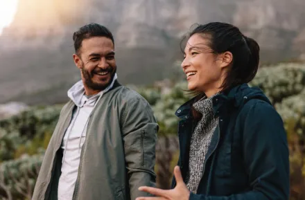 happy married couple smiling and talking on a hike together