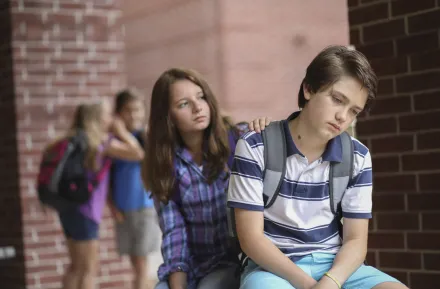 Friend comforts fellow student after he has been bullied