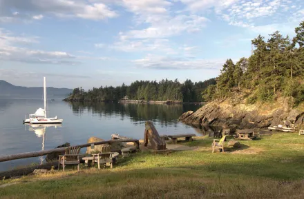 Sailboat in the bay near grassy shoreline at Doe Bay