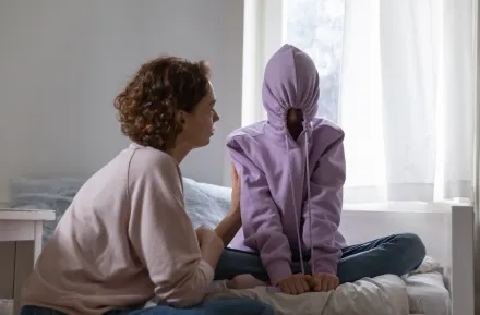 Stubborn teenage girl putting hood on avoiding talk with mom
