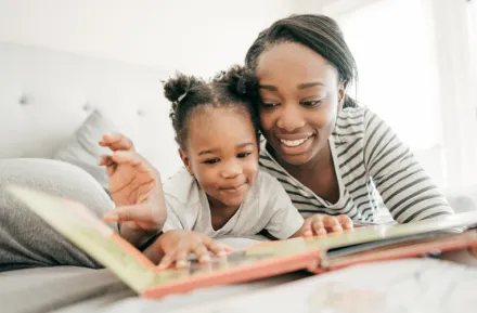 Mom and daughter reading a book about Black history