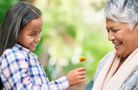 Young girl giving older woman a flower and spreading kindness