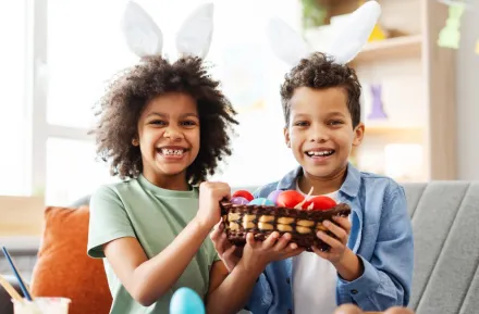 two kids wearing bunny ears holding a basket of dyed eggs and egg alternatives