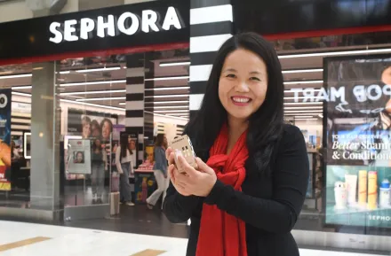 woman holding up a free gift from Sephora on her birthday