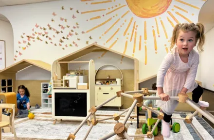 young child on wooden climbing gym at Laro Tayo, an indoor play space for families in Kent
