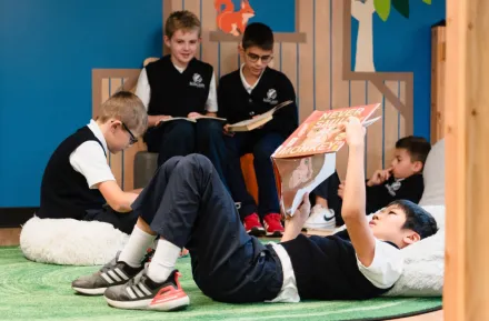 child reading on his back in a library