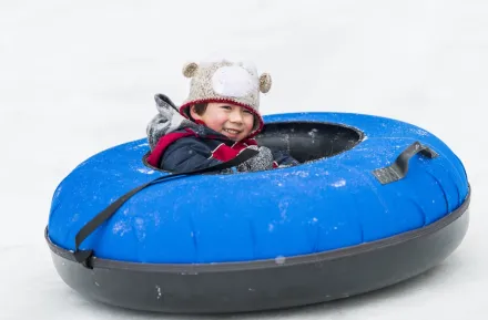 boy in a snow tube having fun