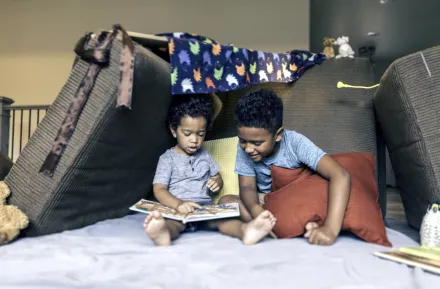 brothers playing in a living room fort