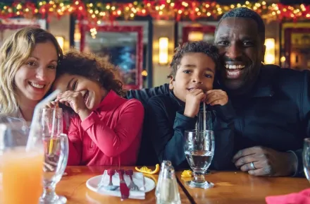 A family enjoys eating a meal out at a restaurant on Christmas Day.